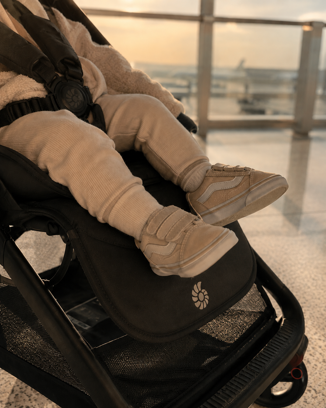 Toddler's shoes resting on the Ergobaby Metro 3 footrest, seat fully reclined